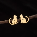 Detalle de pendientes dorados de gato con corazón calado sobre una rama de madera real - Diseño de Gato Altivo Calado (792 Color Acero)