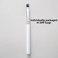 Close-up of a silicone lip brush with a white handle and silver ferrule in opp bag packaging - White