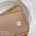 Gros plan du pendentif flocon doré serti de zircons sur fond de soie élégante - Pendentif Flocon de Neige (F124 Or) / Doré