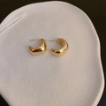 Minimalist gold-tone C-shaped metallic stud earrings on a textured ceramic plate - Gold Minimalist Smooth C Style