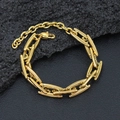 Primer plano detallado de una pulsera de cadena dorada gruesa sobre textura de piedra oscura - Pulsera / Dorado