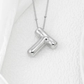 Macro view of polished silver puffy letter T pendant on a minimalist O-chain necklace - Letter T Pendant