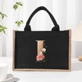 Canvas tote bag with black trim and floral letter I design on white tabletop - Bronze Floral Letter I