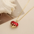 Vista dettagliata della collana con cuore rosso e design a goccia d'oro su sfondo - Rosso