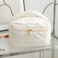 Détail de la trousse de toilette matelassée blanche avec double fermeture dorée - Ivoire