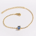 Détail du bracelet doré avec pendentif en zircon vert émeraude et fermoir mousqueton - Bleu