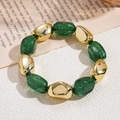Close-up of green glitter resin beads and gold irregular charms on elastic bracelet - Green