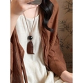 Gros plan d'un collier pendentif en bois vintage avec perles sombres sur un mannequin - Style 2 (HN10354-HN10356) / Marron