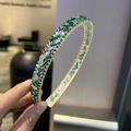Dettaglio di scintillanti cristalli verdi e argento su un cerchietto in metallo dorato - Verde
