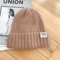 Winter khaki knitted beanie with California 1982 patch on a wooden background - M / Brown