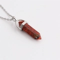 Macro-opname van de rode zeshoekige stenen hanger aan een zilveren metalen ketting - Rood