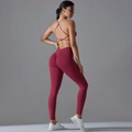 Detail of burgundy sports set featuring cross-back bra and ruched butt lifting leggings - S / Burgundy