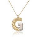 Macro detail of two-tone gold and silver letter G pendant with hammered texture design - Letter G