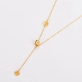 Nahaufnahme der goldenen Edelstahl-Halskette mit Münzanhänger und Quasten-Design - Gold