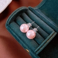 Detalle de pendientes de perlas rosas en un joyero de lujo de terciopelo verde - Pin de Plata S925 / Perla Rosa 12mm