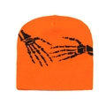 Detailed close-up of orange knit beanie featuring black skeleton hands graphic print - Orange