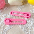 Pair of glossy pink wavy metal hair clips on white lace with tulips background - Rose Red