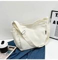Detail view of a white canvas tote bag with side pockets and a red brand woven label - Without Pendant / Off White