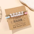 Macro detail of TEACH and INSPIRE teacher gift bracelets on a kraft paper gift card - D1009-1 (2Pcs Set-Pink/Blue/Gold)