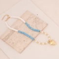 Detailed flat lay of bohemian clay bead necklace with pearl accents and gold heart charm - Camouflage Blue #8