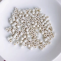 Close-up of white cylindrical acrylic spacer beads for DIY jewelry and phone charms - 4# Cream White