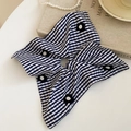 Detail of checkered fabric scrunchie with floral accents on an elegant vintage table - Blue Plaid Floral Style