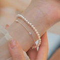 Elegant double-layered silver bracelet with pearls and metal chain on a wrist - Double Layer Pearl Silver Chain Oval Bead (MY38130)