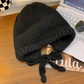 Chunky knit trapper hat in black with side ties on a wooden desk with accessories - Solid Color-Black