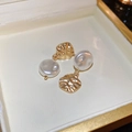 Detalle de pendientes martillados dorados irregulares con elegante perla blanca - Pendientes colgantes geométricos plisados dorados