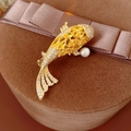 Nahaufnahme der goldenen Koi-Brosche mit gelben Edelsteinen und weißer Perle - Goldener Karpfen Zirkon Stil / Gold