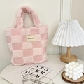 Detail of pink and white checkered plush bucket bag on a minimalist table setup - Light Pink Checkerboard