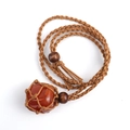 Detail of handcrafted brown net pouch holding a reddish-brown raw stone on a wooden bead cord - Red Agate