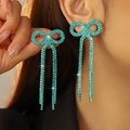 Turquoise bow earrings with long sparkling tassels and rhinestone-encrusted finish - Stud Earrings / Teal