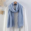 Light blue crinkled cotton linen scarf with frayed edges hanging on a wooden hanger - Light Blue