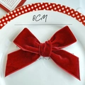 Detail of 8cm burgundy velvet bow decoration placed on a white ceramic cake plate - Velvet Bowknot / Width Approx 8CM / Burgundy