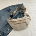 Beige corduroy waist bag with adjustable strap and main zipper closure on denim background - Khaki