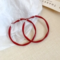 Detail of red oversized twisted hoop earrings with glossy finish on textured background - 42mm Twisted Hoop Style (31#)