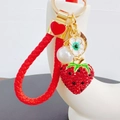 Detailed view of red rhinestone strawberry keychain with woven rope and pearl charm - Strawberry with Heart Lanyard