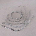 Ensemble de cinq bracelets argentés avec perles blanches et motifs flèches sur tissu gris - 3006