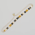 Detailaufnahme von handgewebtem Boho-Armband mit schwarzen, gelben und weißen Perlen - Schwarz Weiß Ingwer Gold