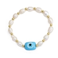 Detail of freshwater pearl bracelet with golden beads and a blue evil eye lucky charm - Light Blue