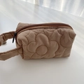Macro detail of brown quilted floral makeup bag with textured flower pattern and zipper - Quilted Floral Brown