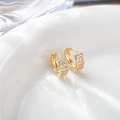Macro shot of gold zircon earrings with double-row micro-inlay on a white ceramic tray - 11x11mm / Gold