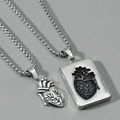 Macro shot of silver anatomical heart and square plate pendants for couples jewelry - Heart Pendant + Tag Pendant / Silver Pair