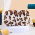 Detailed view of plush leopard print makeup bag on a soft minimalist display stand - Beige Leopard