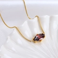 Golden square chain necklace with a dark red marquise gemstone on a white shell tray - Cancer