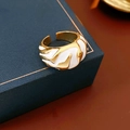 Dettaglio dell'anello dorato a onde con smalto bianco sul bordo di un portagioie blu - Aperto Regolabile / Bianco
