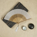 White silk folding fan with bamboo ribs and matching white tassel on a rustic wooden base - White / 23CM