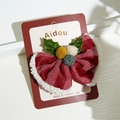 Detail of red Christmas bow hair clip with white faux fur trim and holly leaf decoration - Christmas Bow