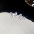 Dettaglio macro di orecchini a fiocco con perle e pietre di zircone scintillanti su argento - Argento (Perno in argento)